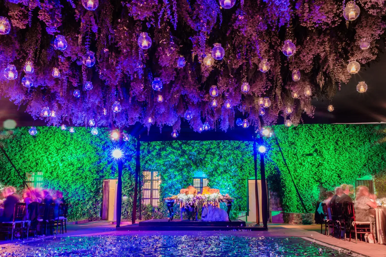Techo de flores colgantes con esferas de luz sobre la pista y la mesa de novios