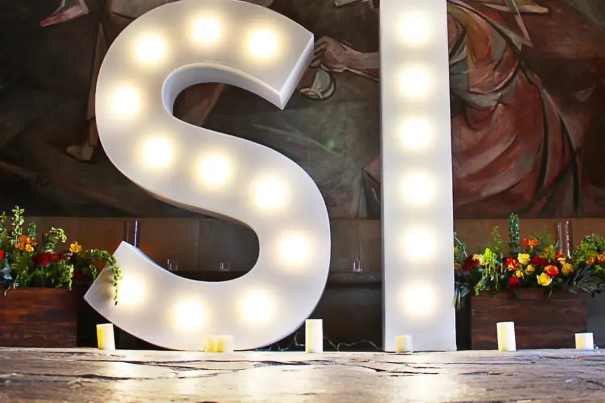 Letras «SÍ» de luz frente a un mural