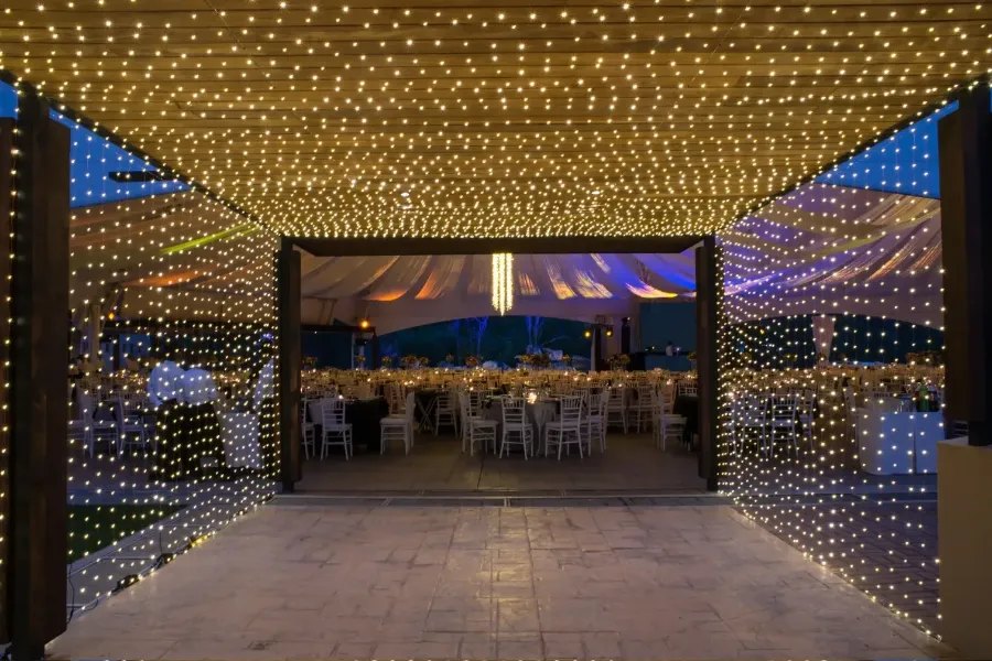 Pabellón de cortinas de luz que abre a un salón de banquete