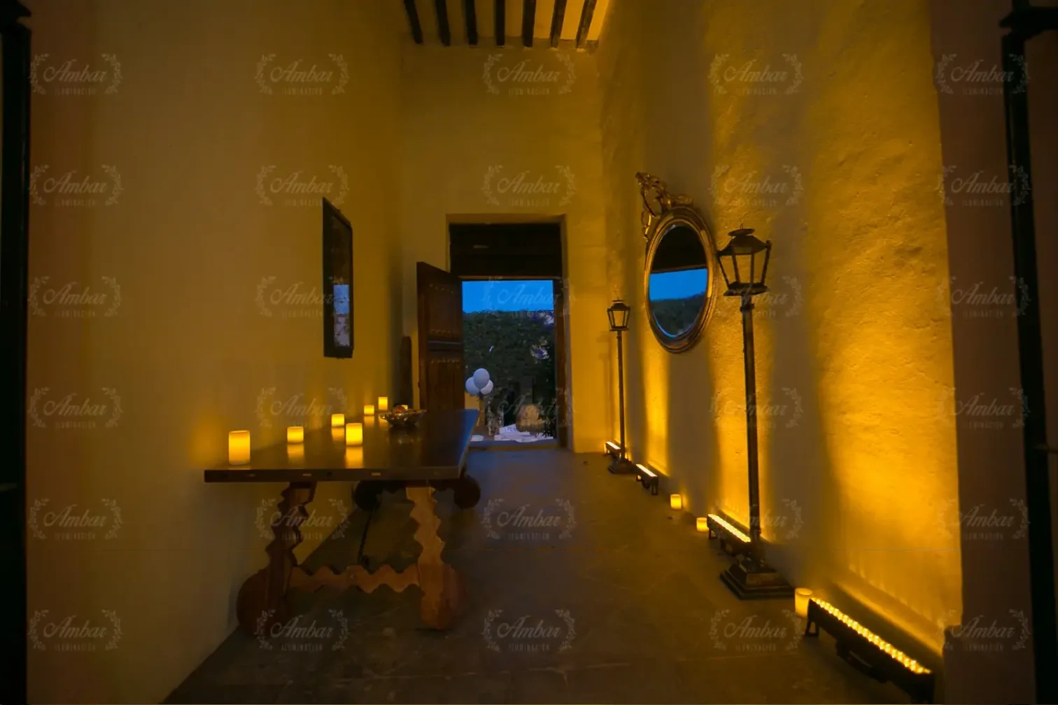 Pasillo con luz rasante cálida, velas y espejo