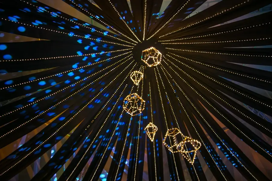 Rosetón de telas con figuras geométricas de luz, visto desde abajo