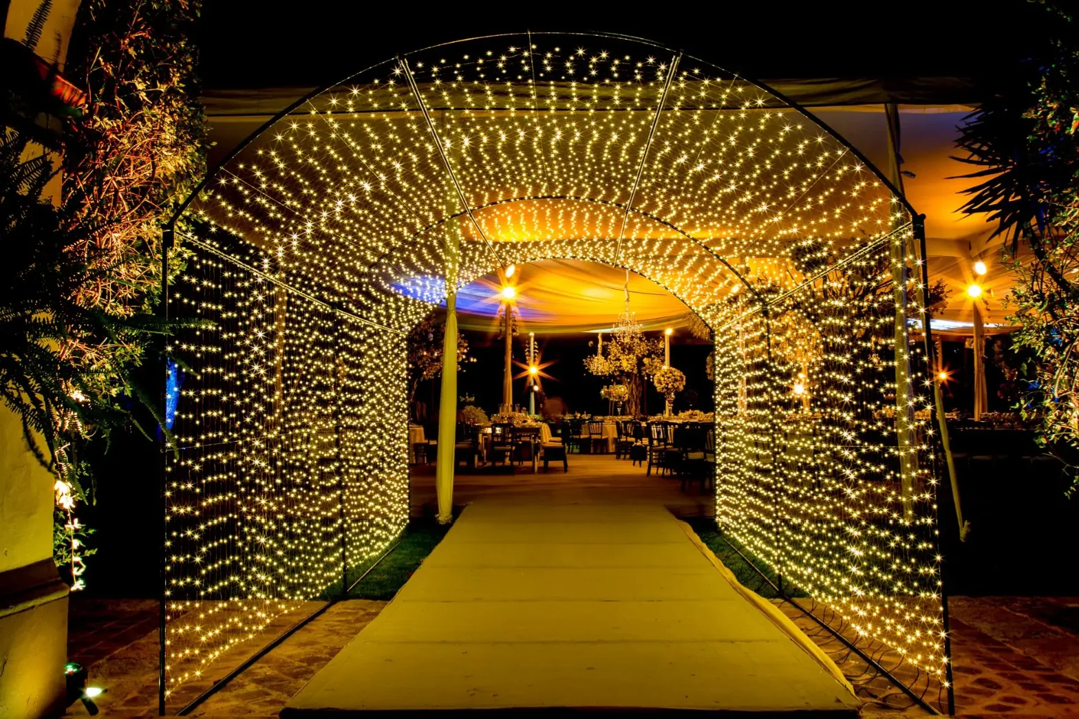 Túnel de luces cálidas que lleva al banquete